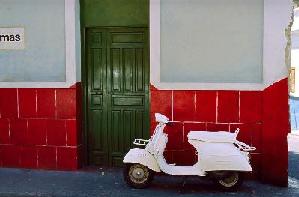 white vespa in front of colorful housefacades